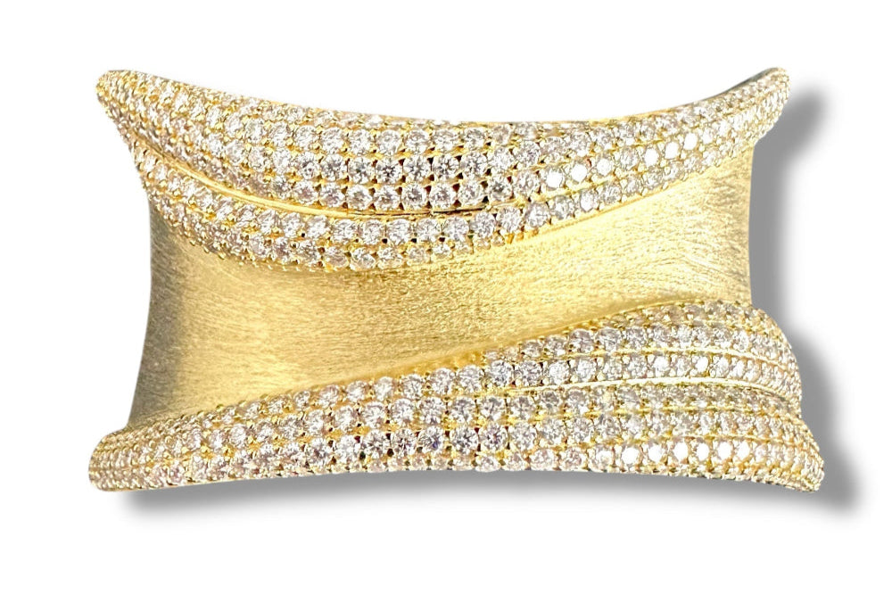 This beautiful statement cuff features 503 individually set round brilliant clear moissanite gemstones throughout the setting for a combined weight of 12.03 carats. With its beautiful texture, this classic and timeless creation is crafted from solid sterling silver with multiple layers of 18kt yellow gold plating. A show-stopping bangle that’s sure to be noticed! A great addition to any collection.